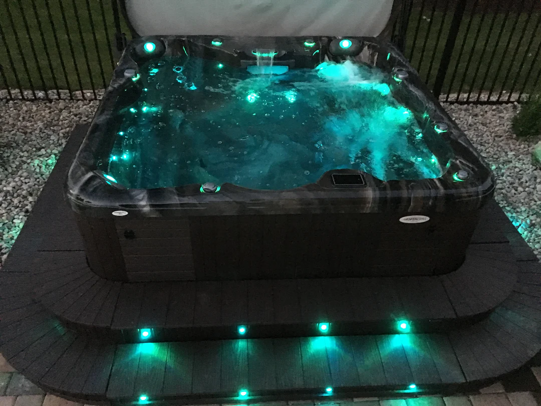 Aspen Spas hot tub with illuminated features, showcasing a relaxing water surface and inviting ambiance, designed for comfort and hydrotherapy.
