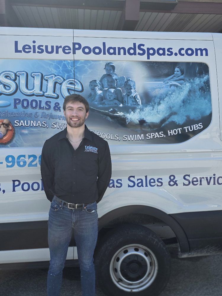 Steve, service technician at Leisure Pools & Spas, standing in front of company van with branding, showcasing expertise in pool and hot tub maintenance.