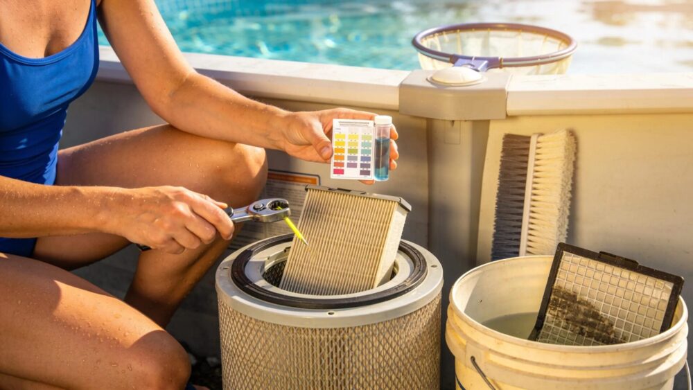 Homeowner checking water chemistry and cleaning filter of above ground pool